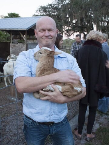 Mike from Chili Pepper Madness Holding a Sheep at the King Family Farm.