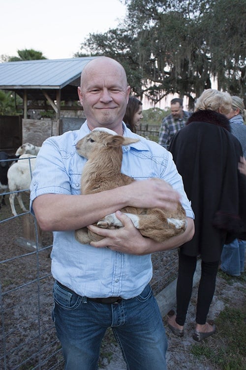 Mike from Chili Pepper Madness Holding a Sheep at the King Family Farm.