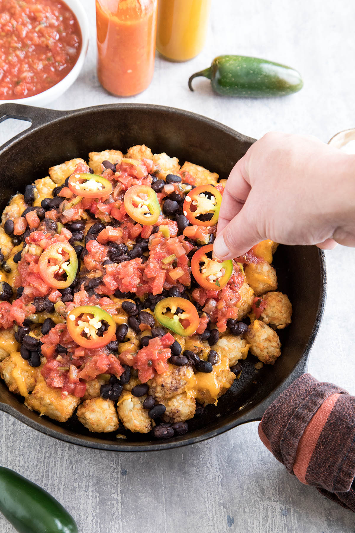 Adding peppers to the skillet.