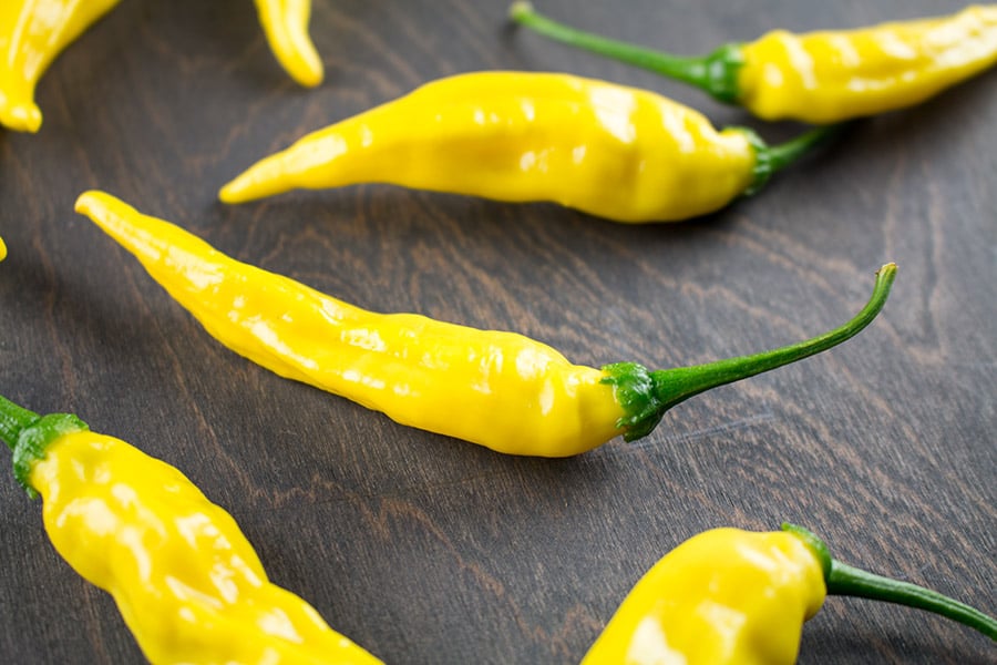 Aji Pineapple Chili Peppers on a wooden surface