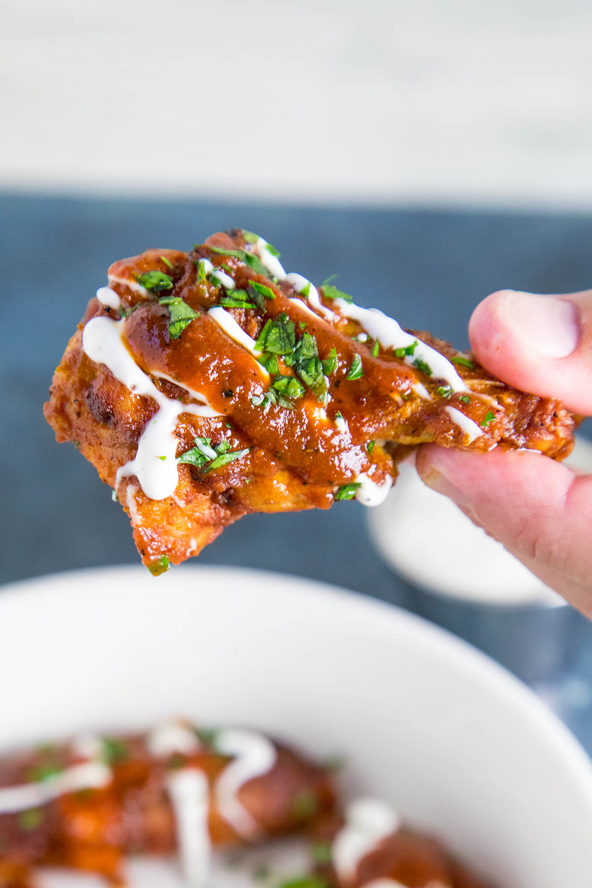 Holding one of the delicious Ancho BBQ Chicken Wings