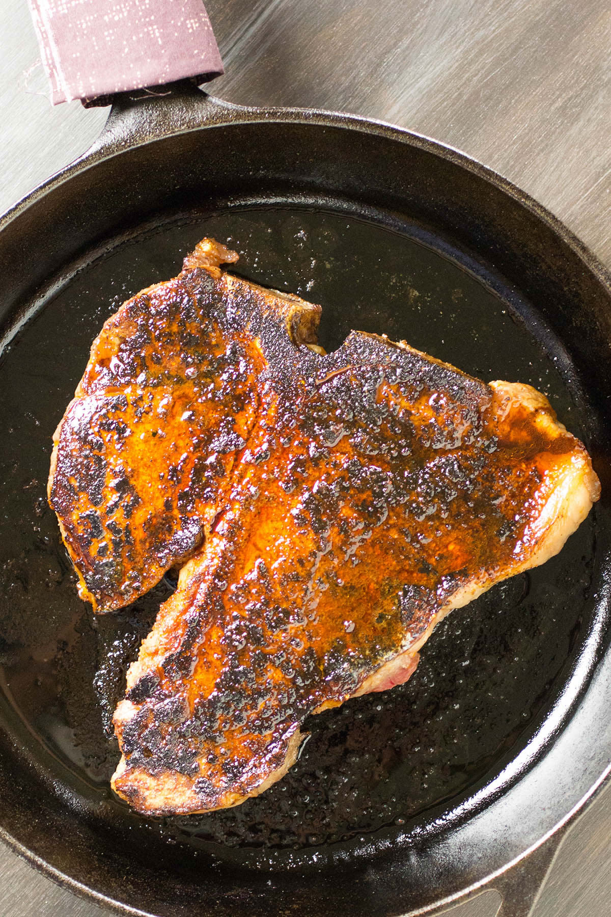 The Ancho Crusted Porterhouse Steak searing in a skillet