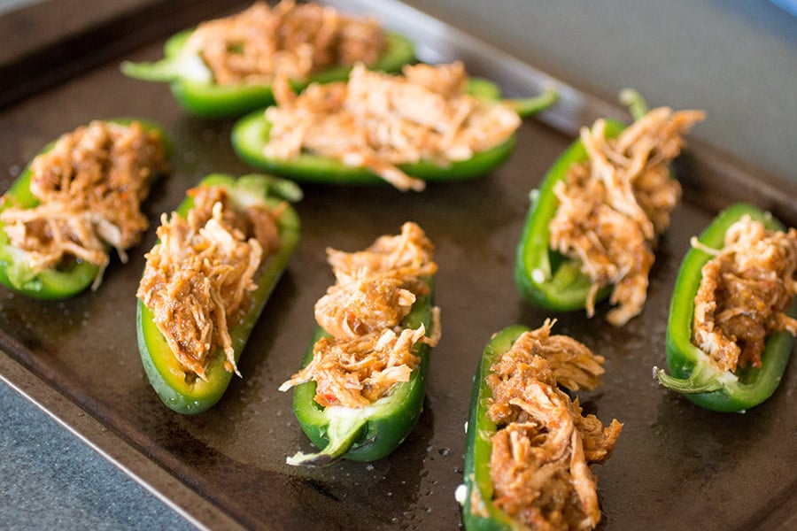 Stuffing the jalapeno slices with shredded chicken.