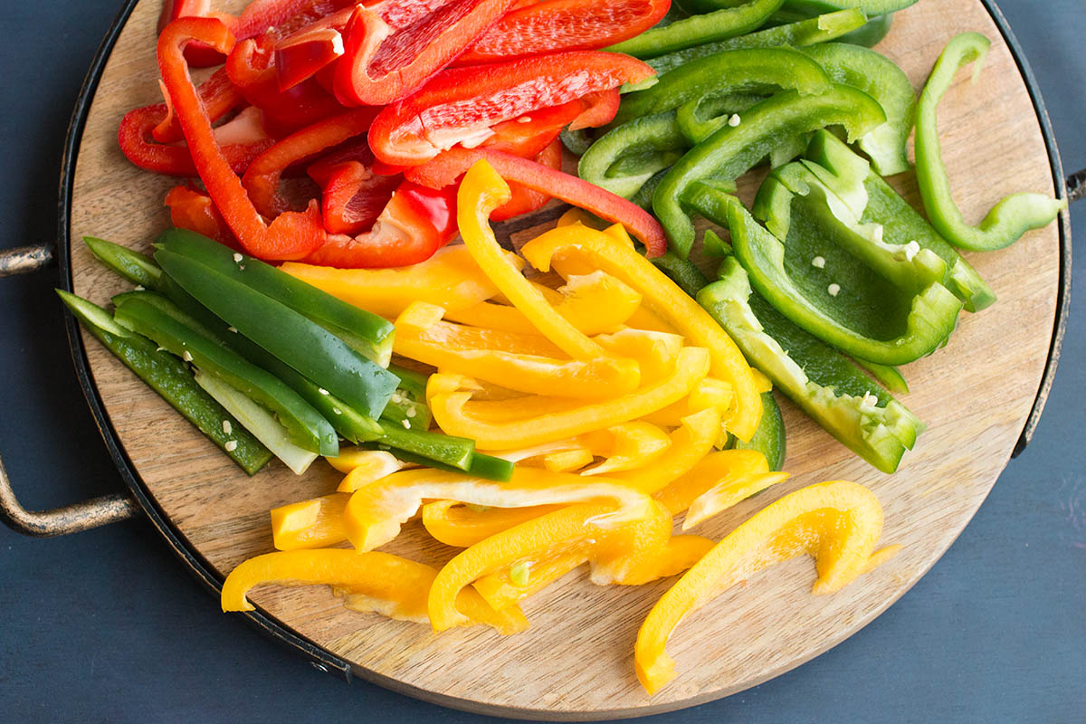 Sliced Bell peppers on a wooden baord.