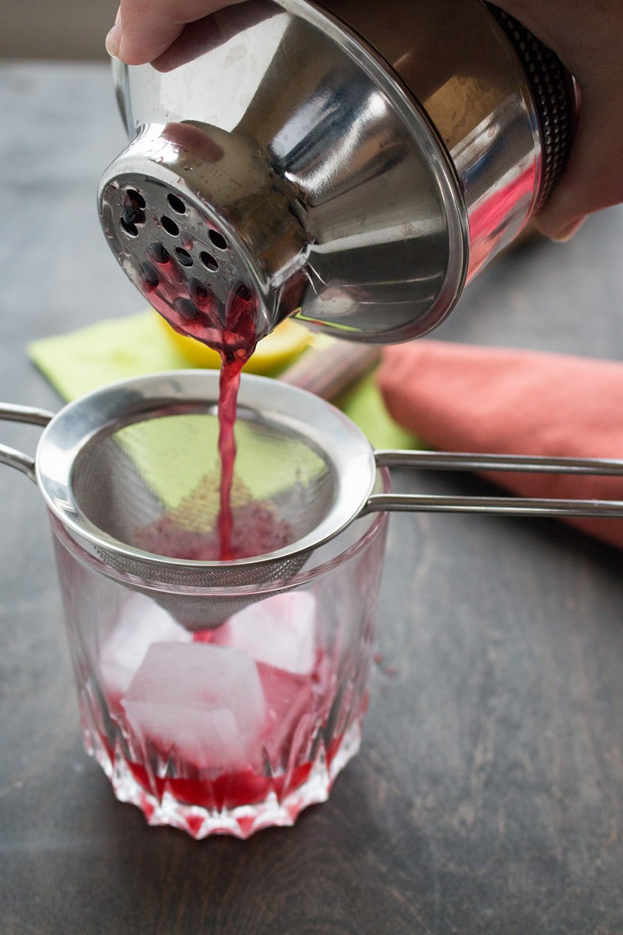 Pouring Blackberry Elderflower Cocktail into the glass with ice