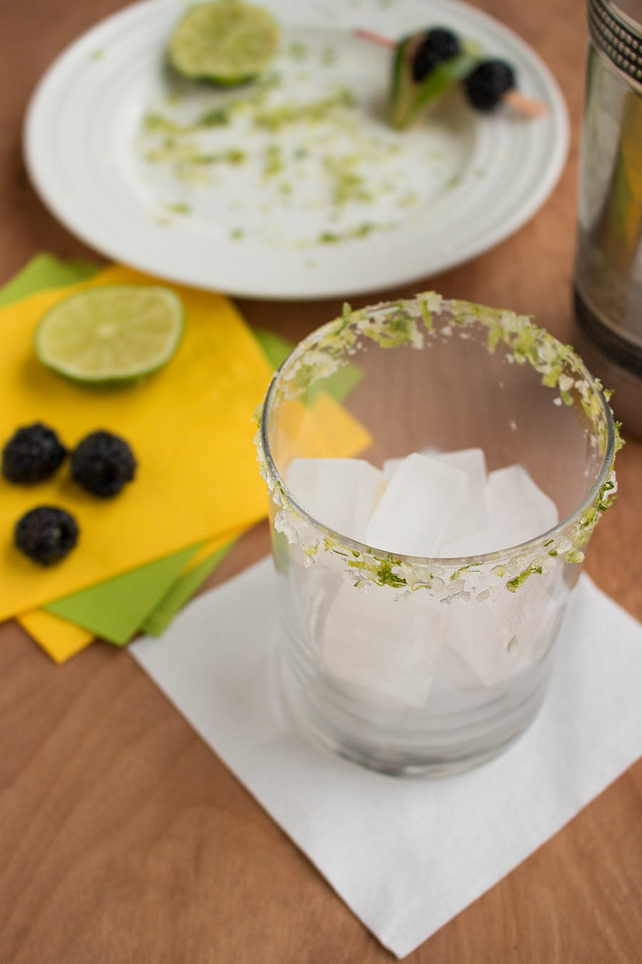 Adding ice to a glass to make Spicy Blackberry Habanero Margarita