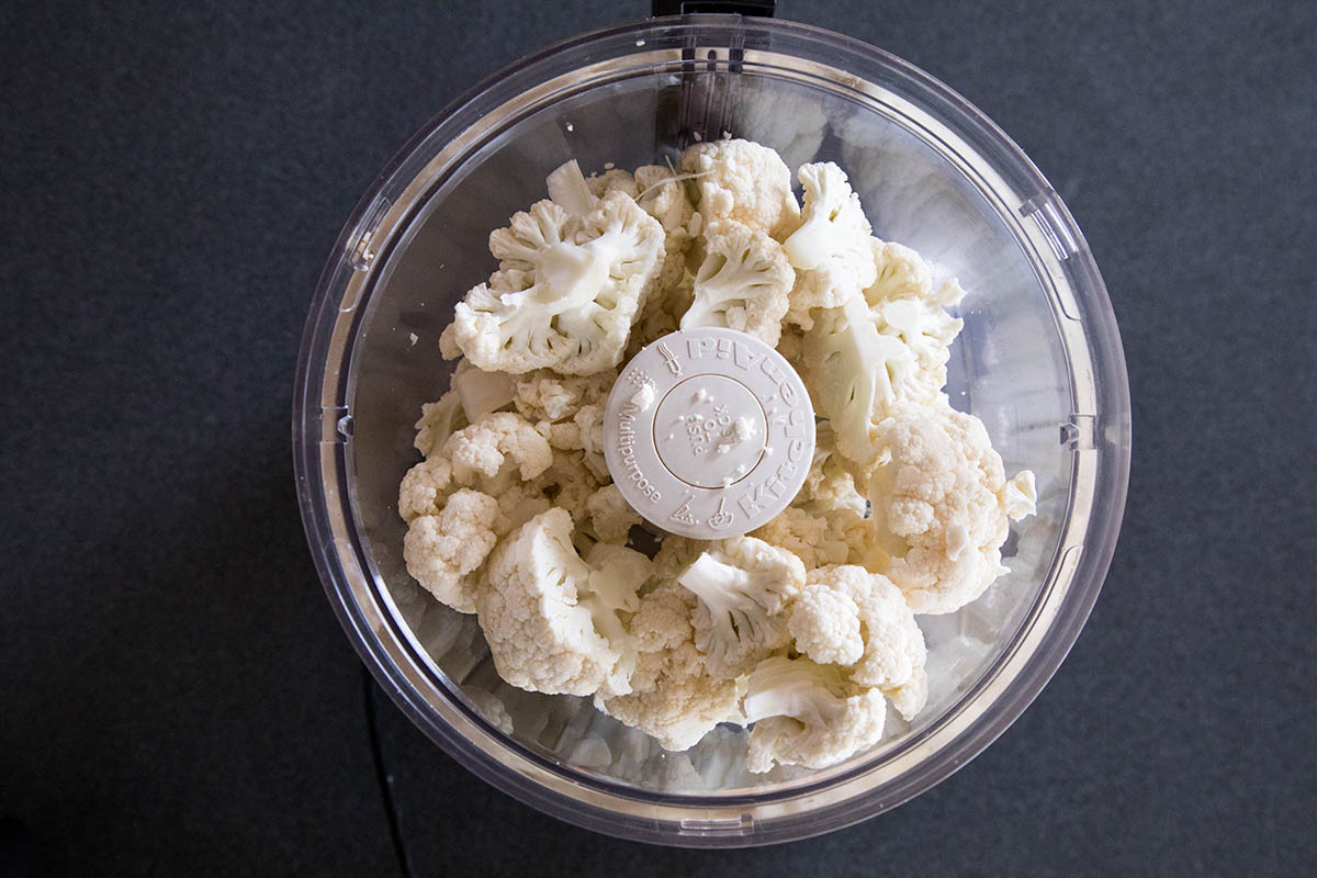 Making Cajun Cauliflower Rice - Add the Cauliflower to a Food Processor.