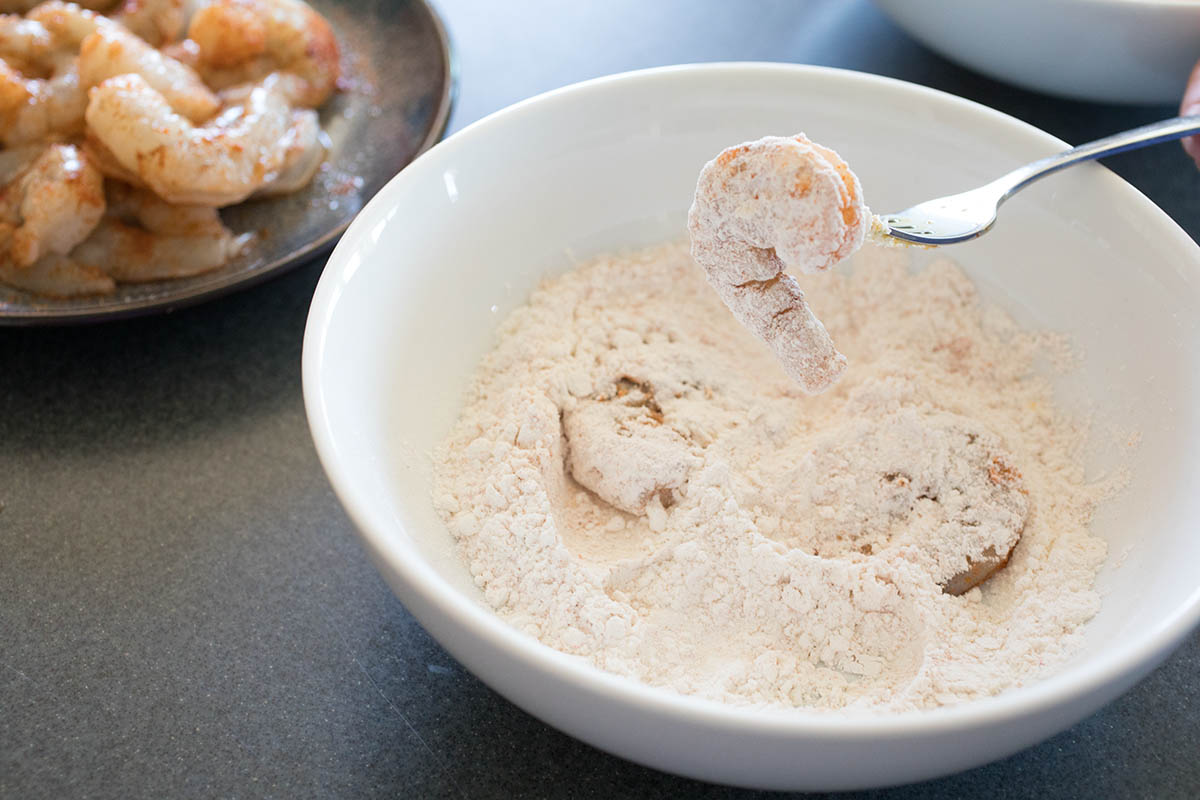 Dredging shrimp into the flour.