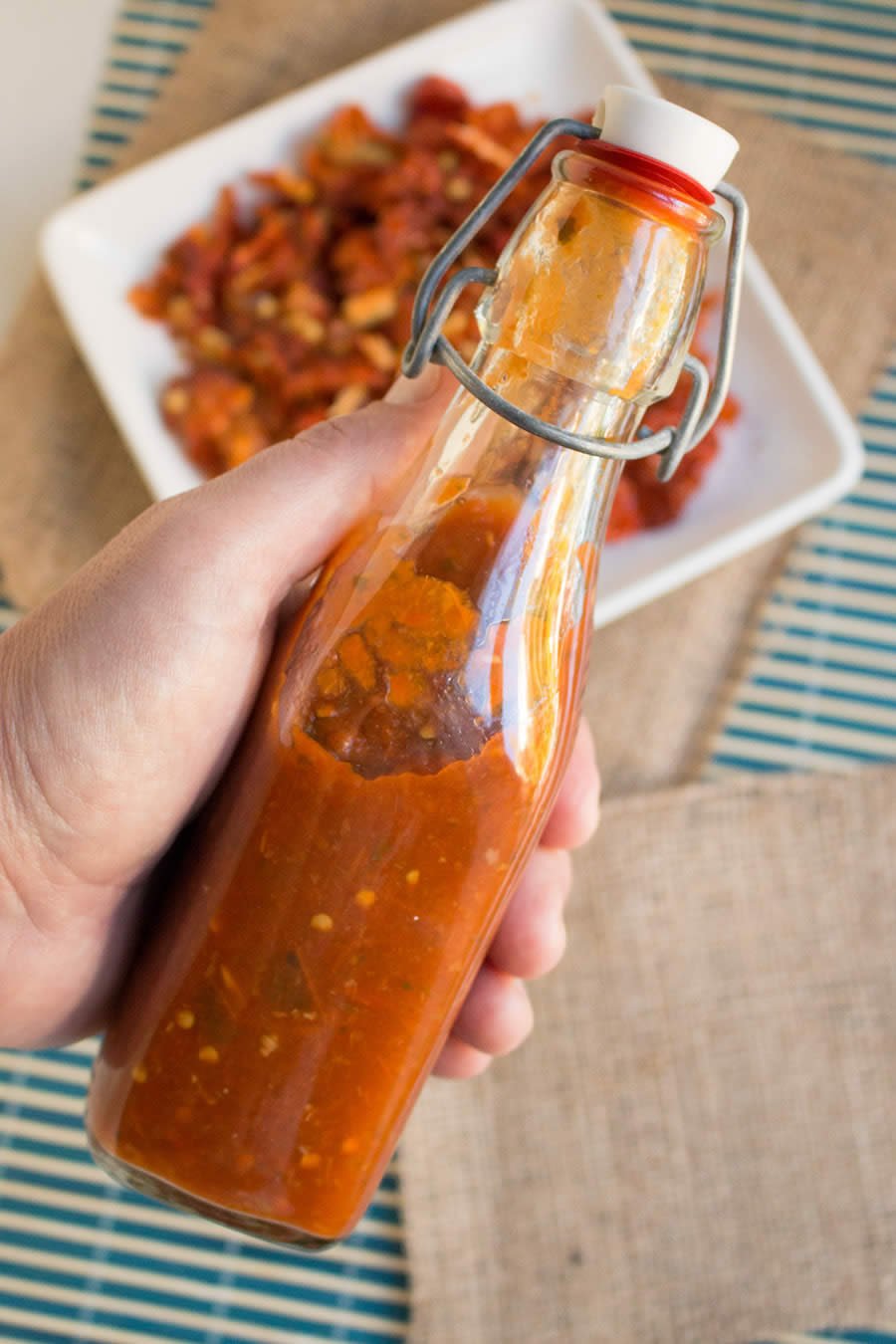 Holding a bottle full of the delicious Homemade Cilantro-Habanero Hot Sauce 
