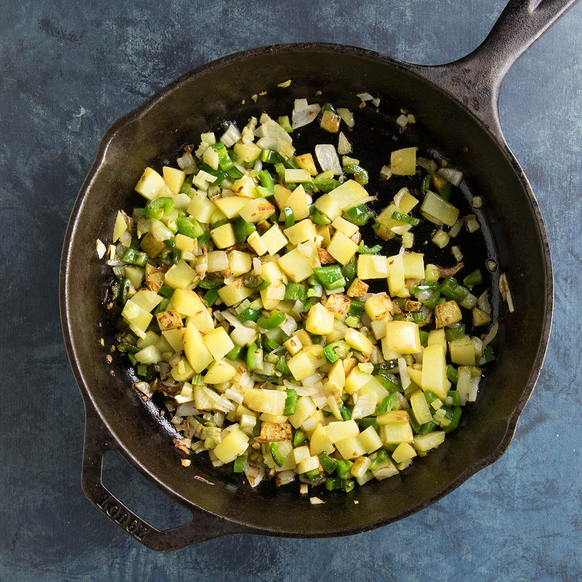 Cooking onions, peppers, celery, potato, and garlic in a hot pan with a bit of butter.