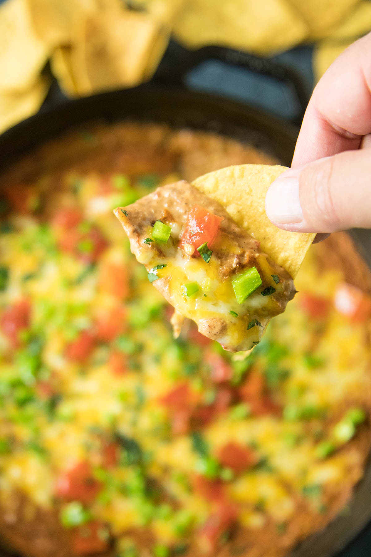 Dipping a chip into the Easy Cheesy Chipotle Bean Dip.