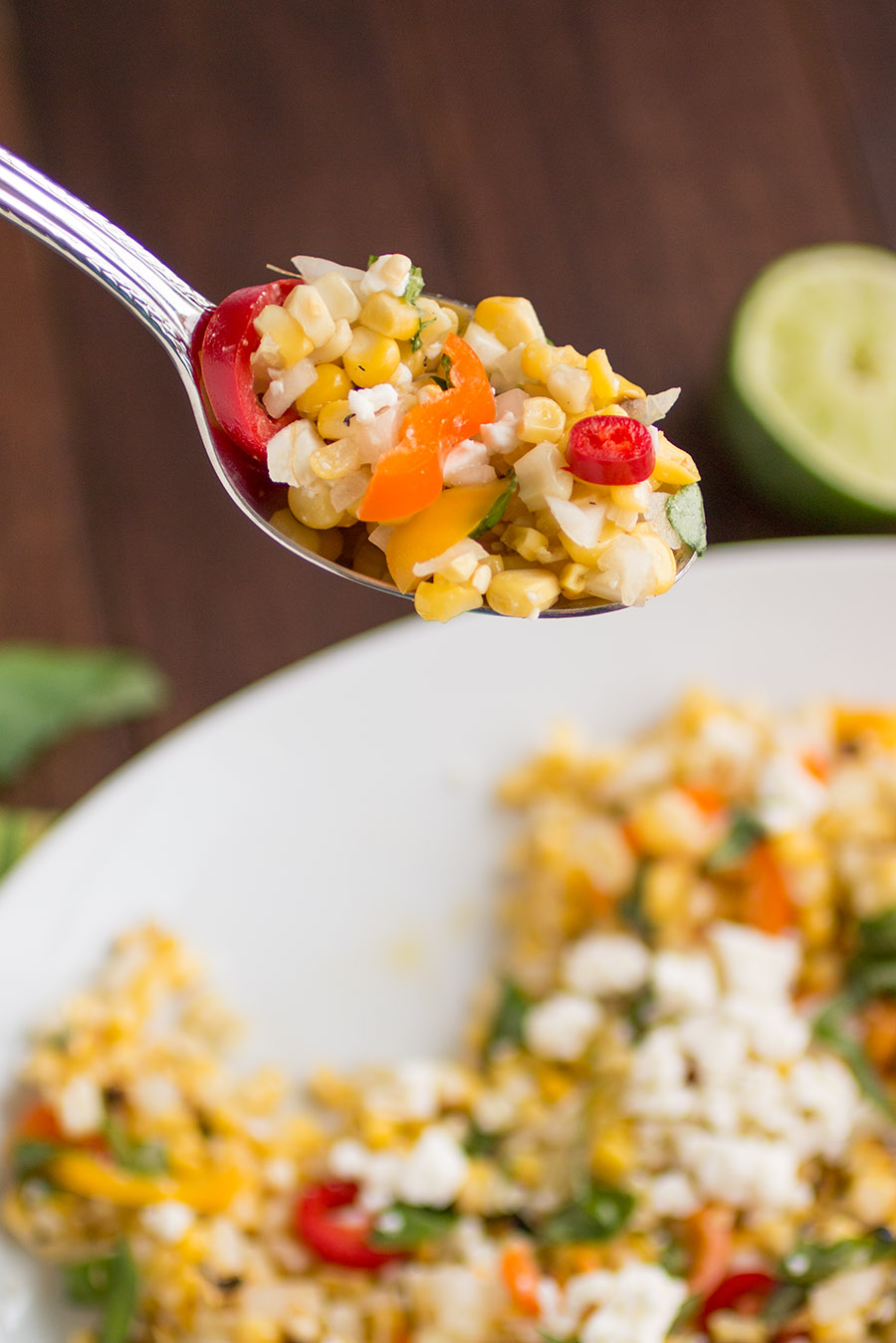 A spoonful of the delicious Grilled Corn Salad with Feta and Sweet Peppers
