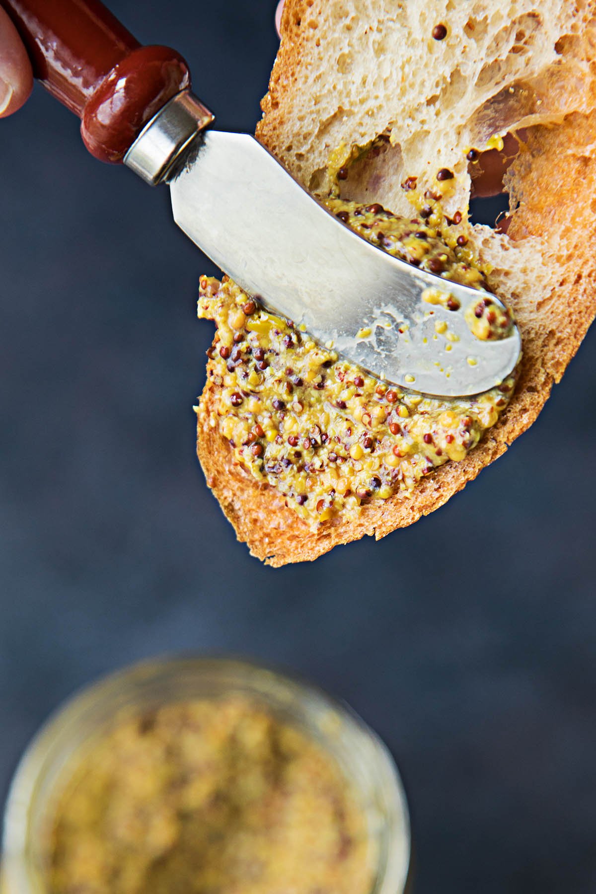 Spreading the Roasted Hatch Chile-Beer Mustard on a piece of bread