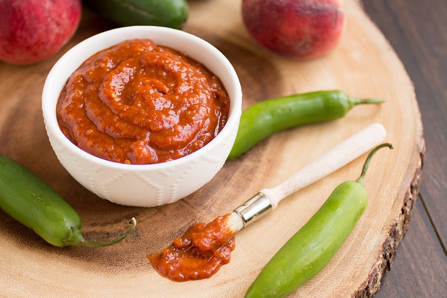 Homemade Peach-Bourbon Barbecue Sauce served in a small white bowl.