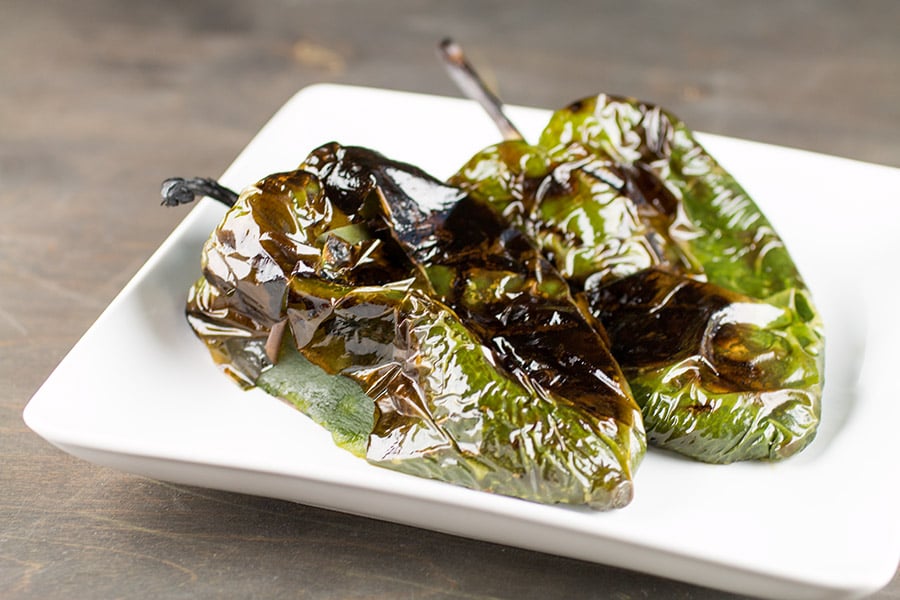 Grilled Poblano Peppers on a white tray.