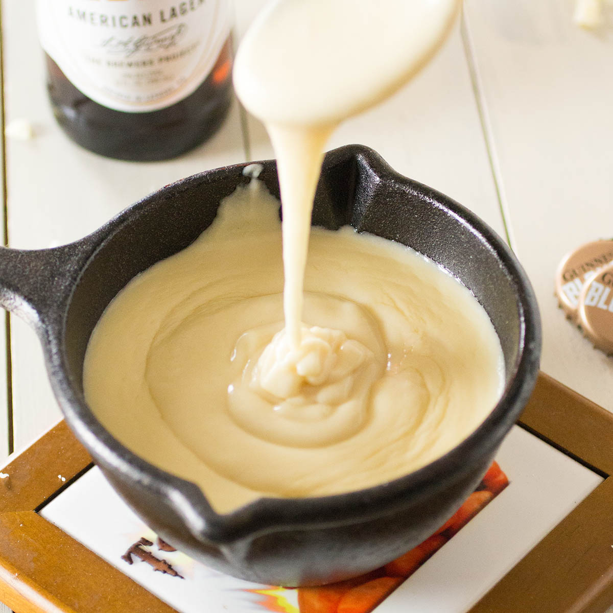 Pouring the beer cheese sauce into the serving skillet