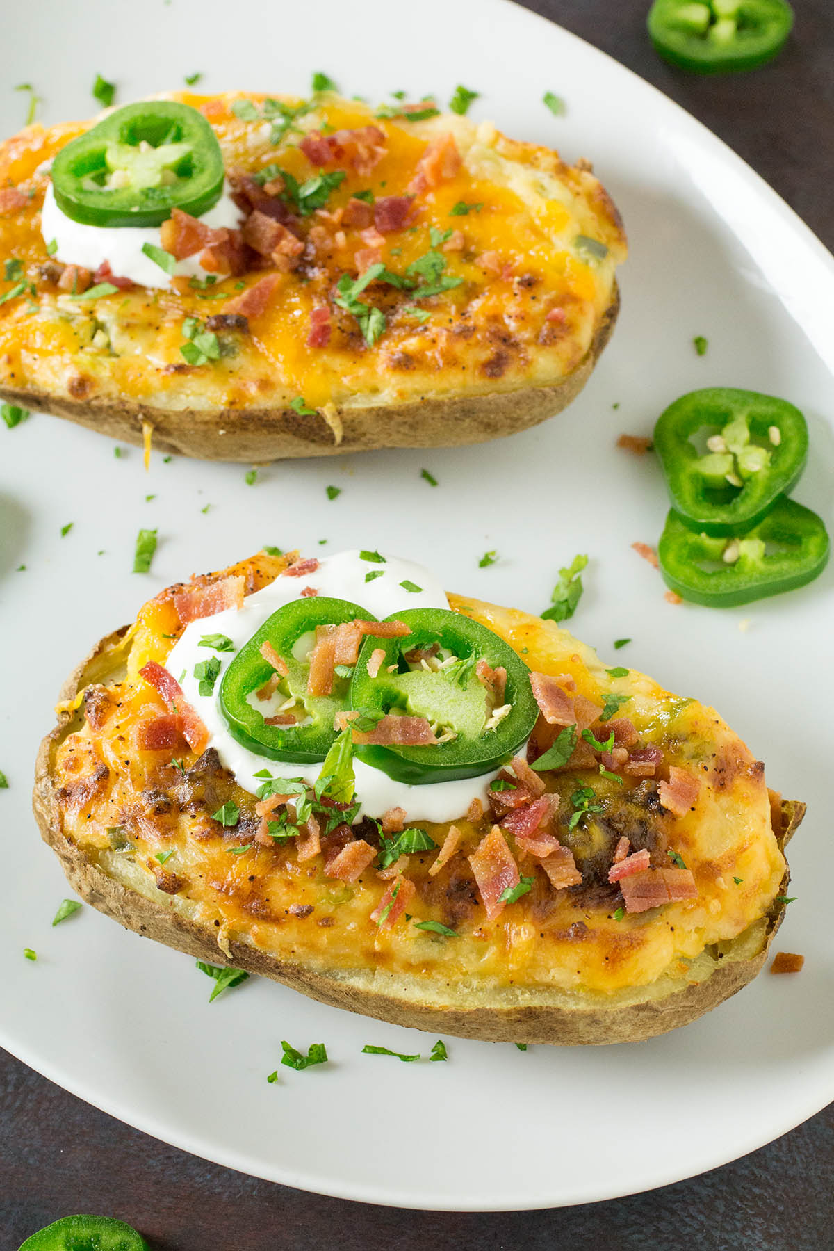 Jalapeno Popper Twice Baked Potatoes with lots of jalapeno slices around them.
