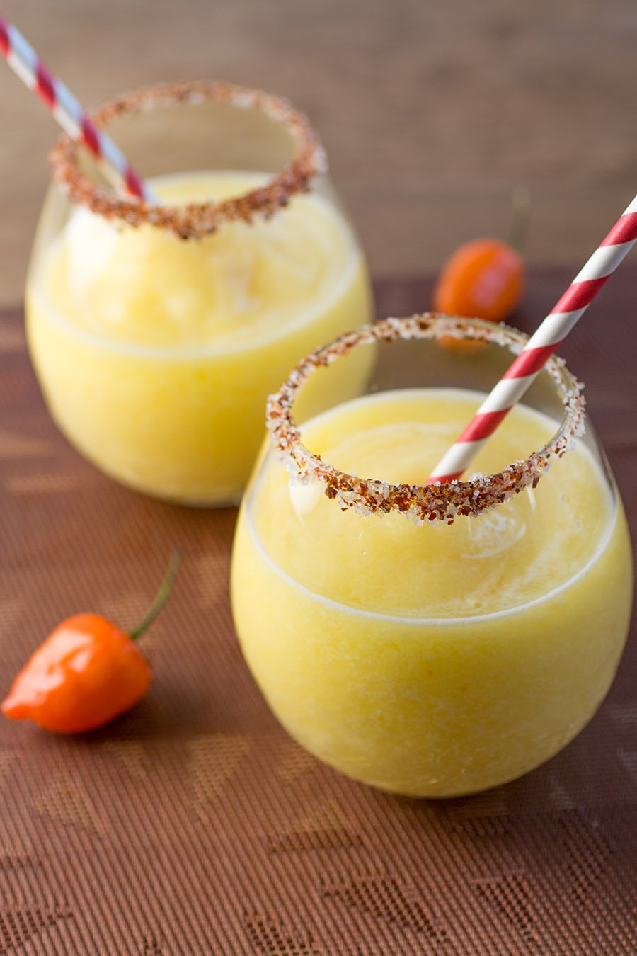 Mango Habanero Margaritas with peppers around the glasse.