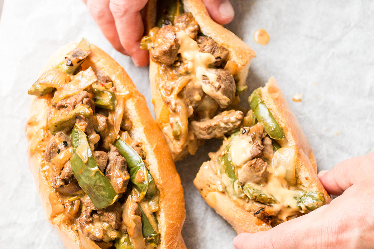 Cutting Mexi Cheesesteak Sandwiches in two halves