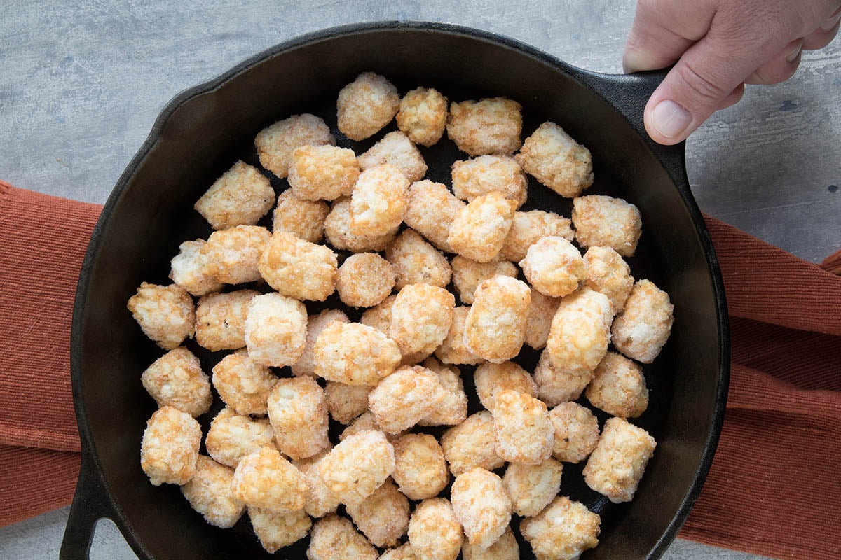 Preparing Cheesy Game Day Totchos (Tater Tot Nachos).