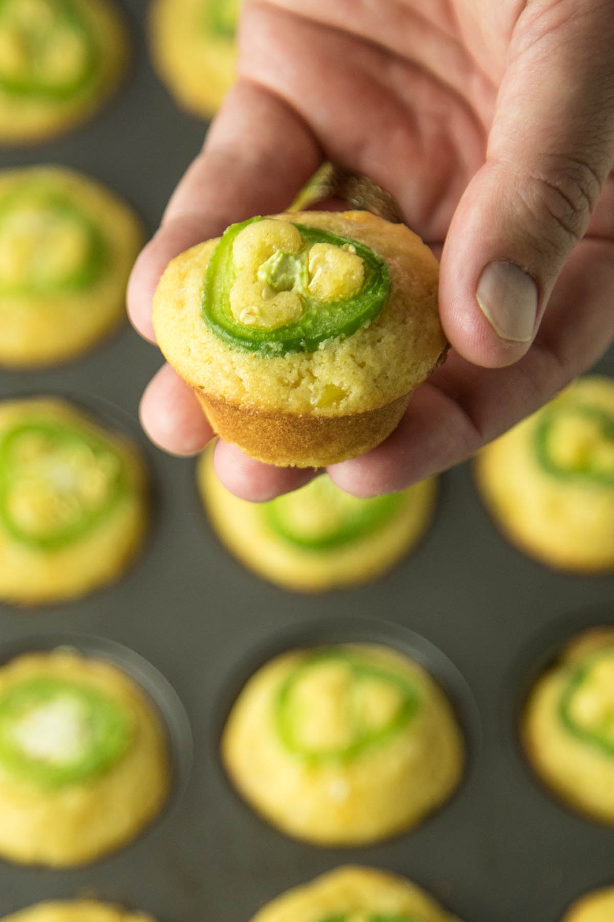 Holding one of the Cheesy Jalapeno Popper Cornbread Muffins