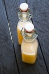 Peach Sugar Rush Hot Sauce served in two jars on the wooden surface