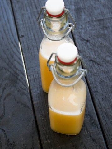 Peach Sugar Rush Hot Sauce served in two jars on the wooden surface