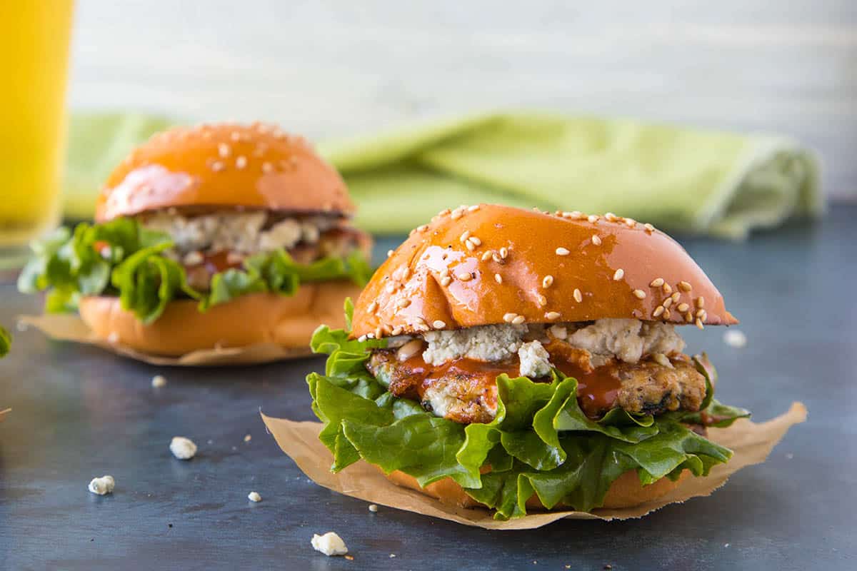 Buffalo Blue Cheese Chicken Sliders on buns with leafy lettuce and dripping Buffalo sauce
