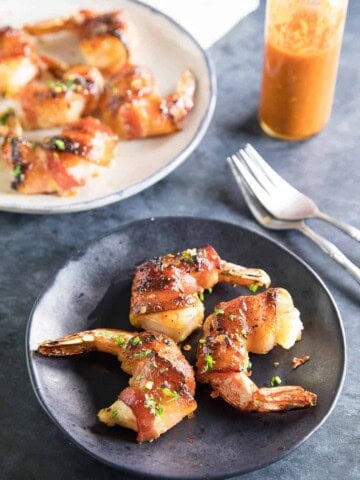 Habanero-Honey Glazed Bacon Wrapped Shrimp served on a plate.