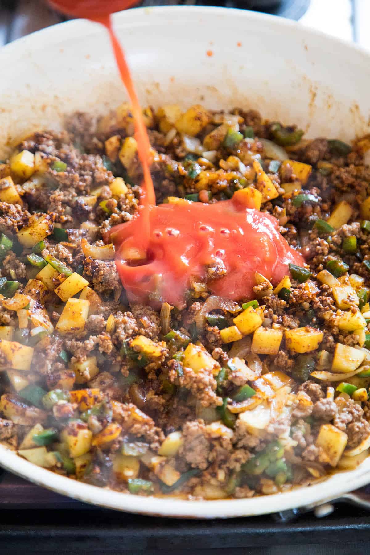 Pouring the Tomato Sauce for our Homemade Mexican Picadillo Recipe