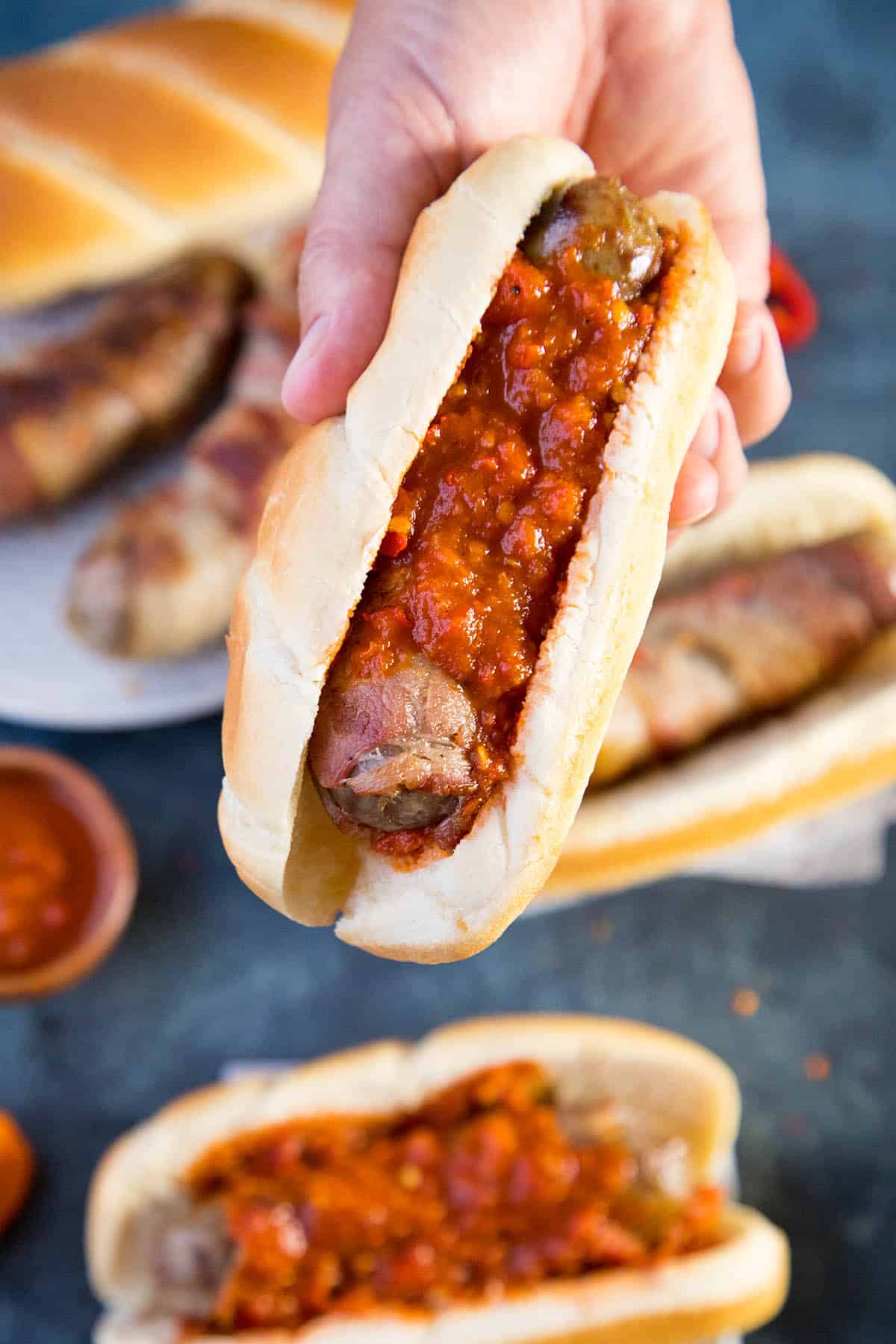 Bacon Wrapped Beer Brats with lots of spicy habanero sauce.