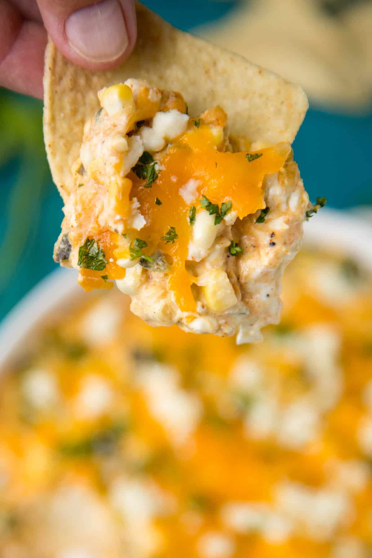 Cheese dip with roasted poblano peppers and corn. served on a corn chip.