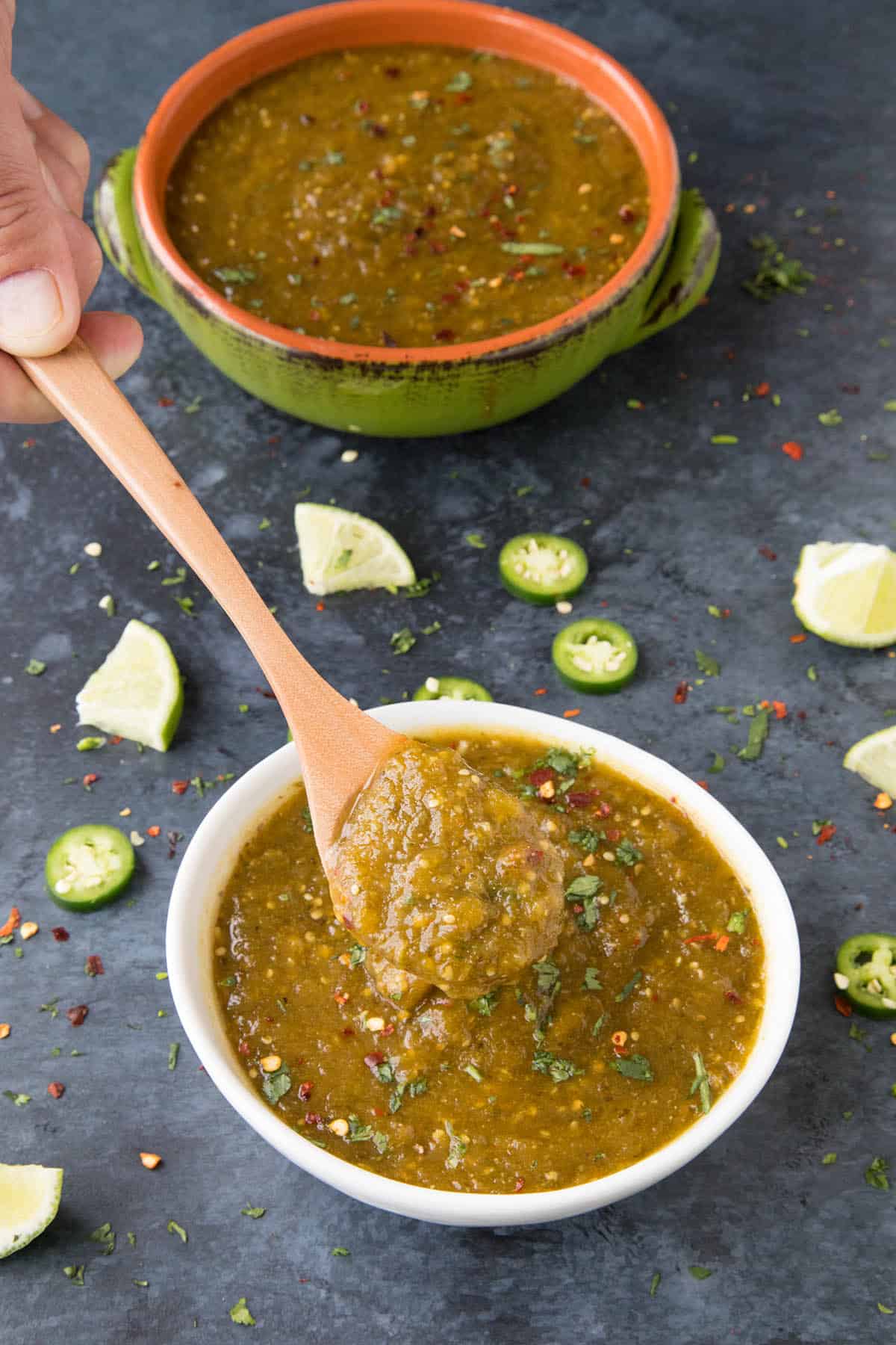 Green enchilada sauce on a spoon, ready for cooking