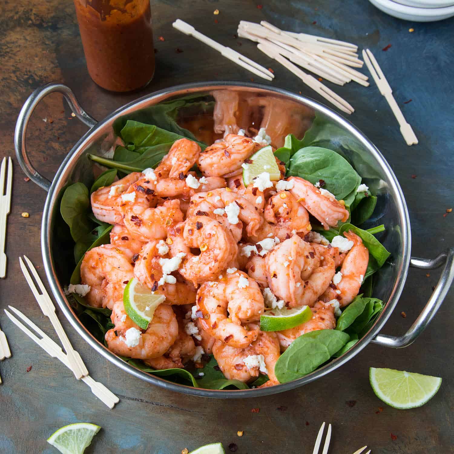 Grilled Buffalo Shrimp in a bowl over spinach leaves.