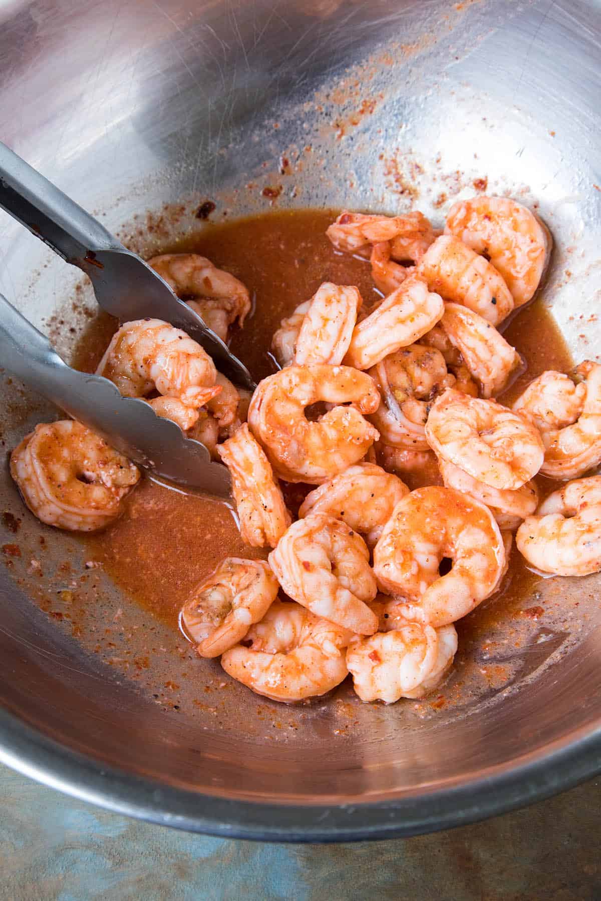 Tossing the shrimp in homemade Buffalo sauce.