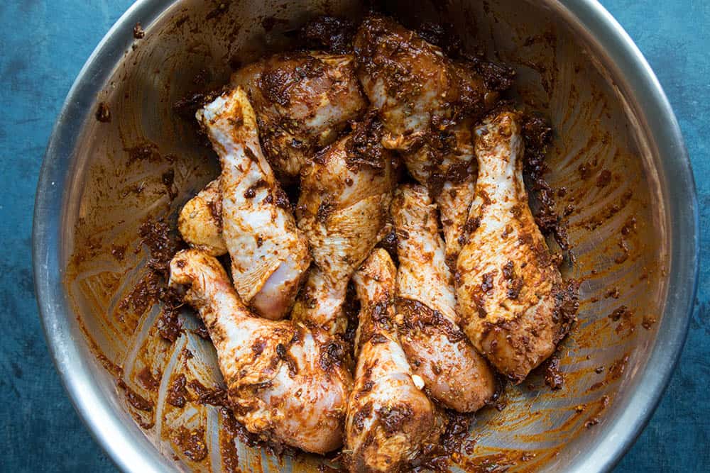 Grilled Harissa Chicken Legs - Marinating in a bowl with freshly made harissa