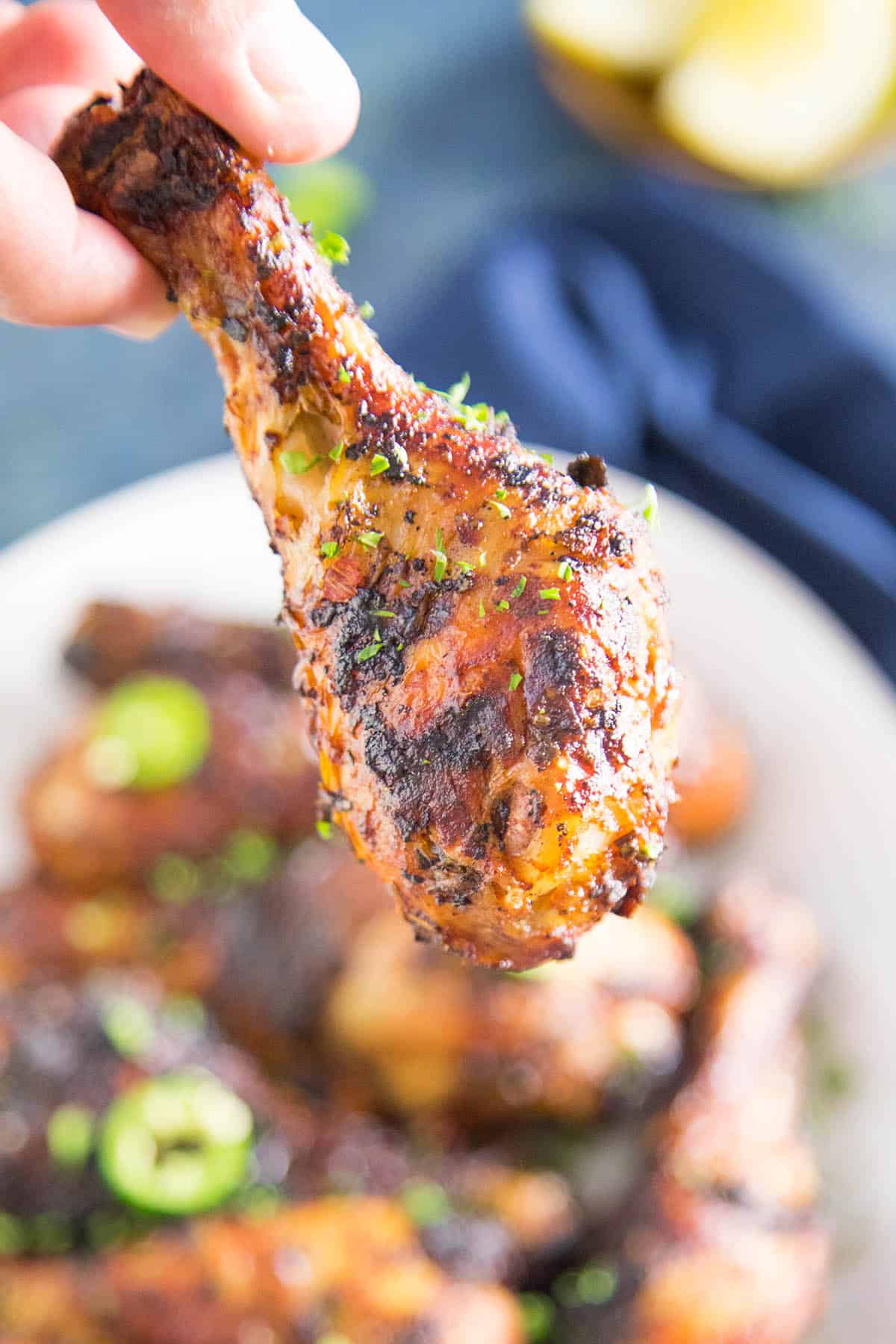 Grilled Harissa Chicken Leg in hand, ready to eat