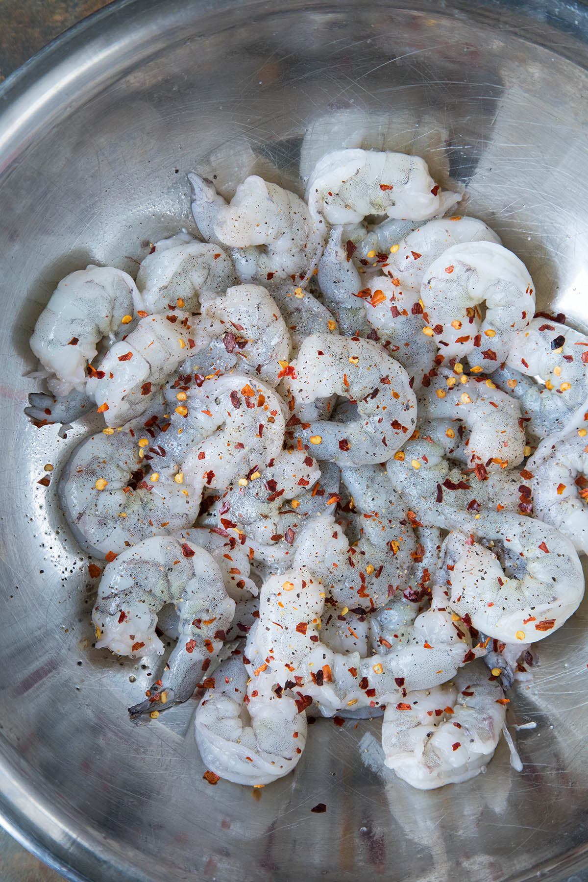 Season the shrimp with chili flakes and seasonings.