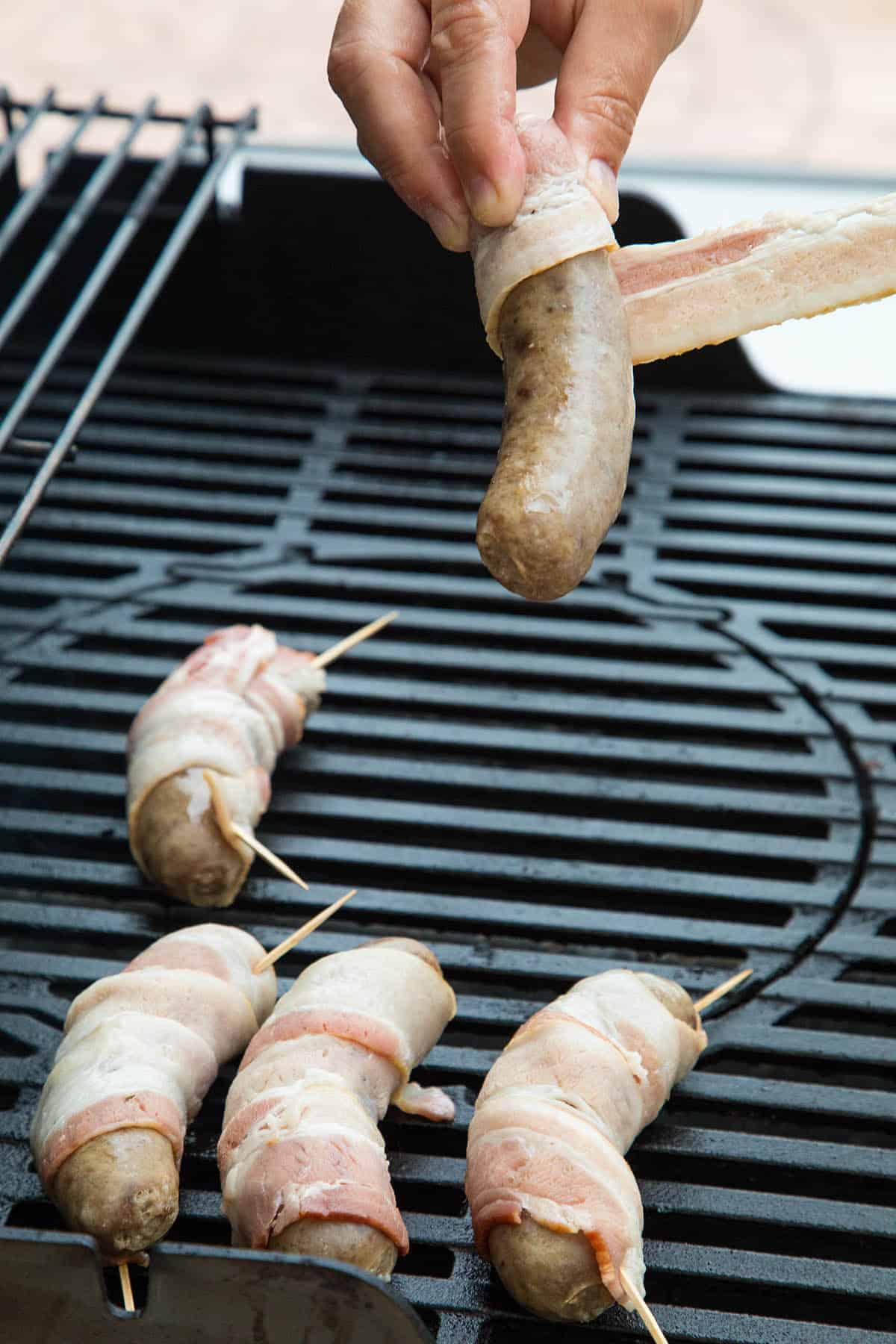 Wrapping Sausages in Bacon for the grill.
