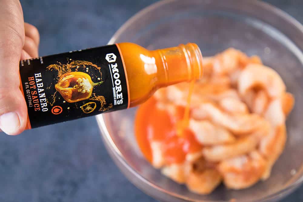 Pouring Moore's Habanero Hot Sauces