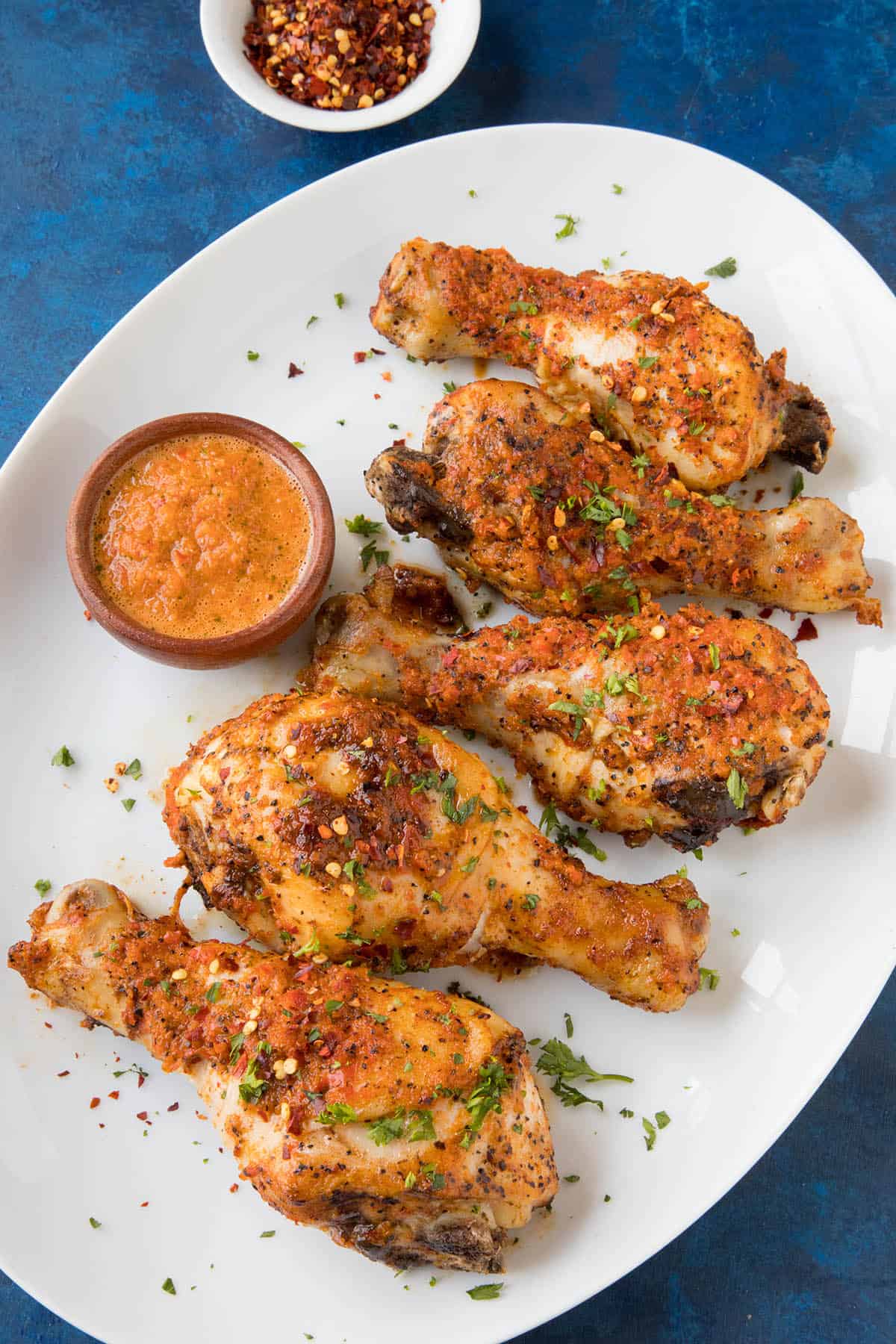 Peri Peri Chicken Legs - On a plate with extra peri peri sauce on the side
