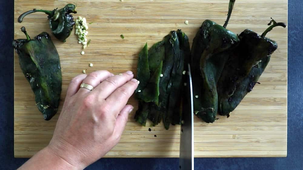 Slicing the roasted poblano peppers into strips, or "rajas"