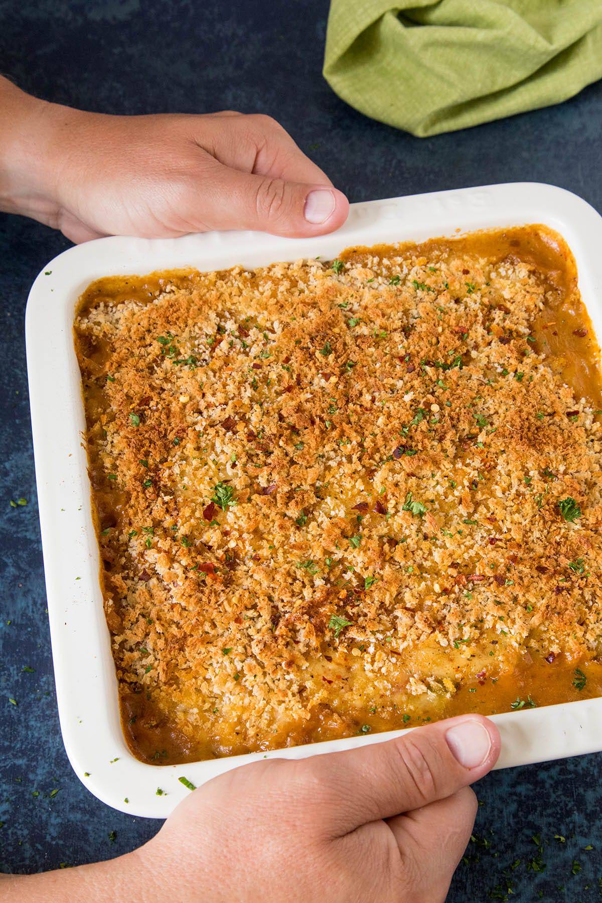 Setting the Creamy Cajun Chicken Casserole onto the table.