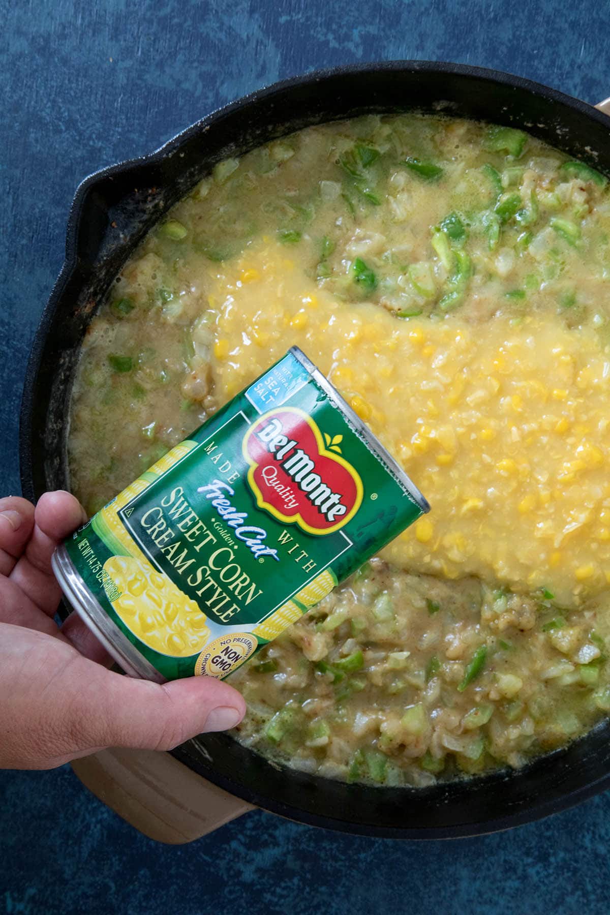 Pouring the Cream Style Corn into the chicken casserole.