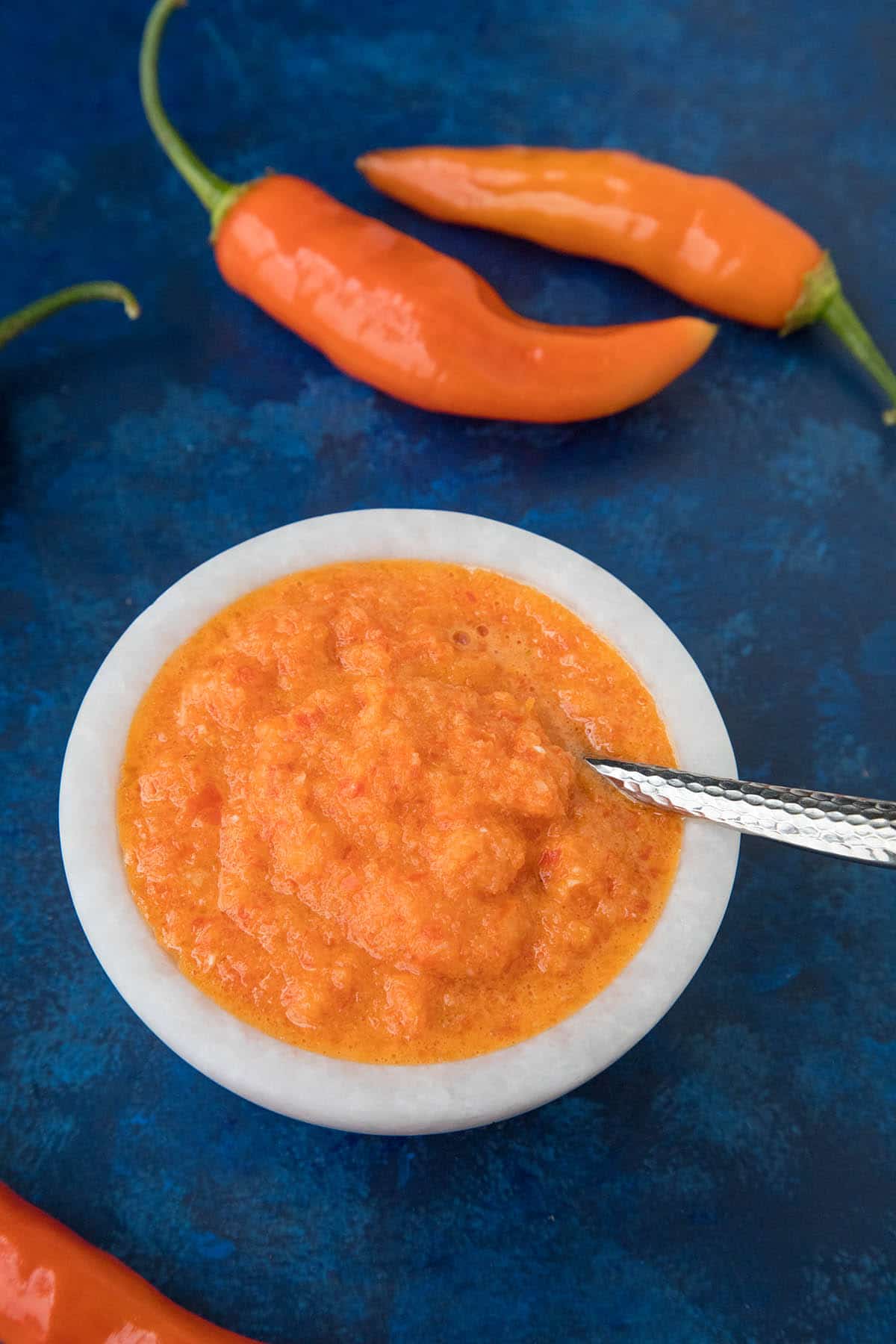 Aji Amarillo Paste with peppers around the bowl