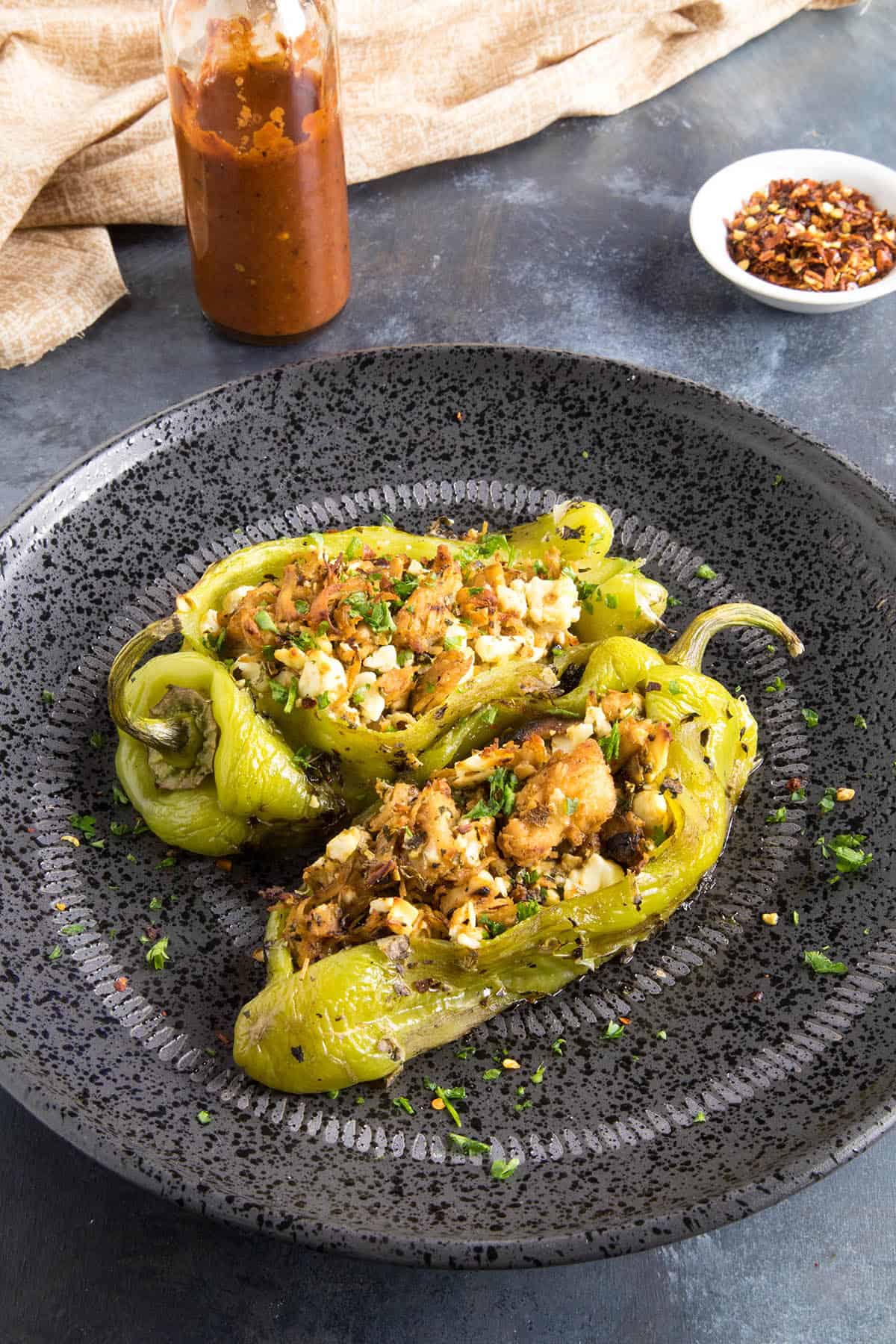 Chicken and Cheese Stuffed Anaheim Peppers - Served up on a plate with hot sauce on the side