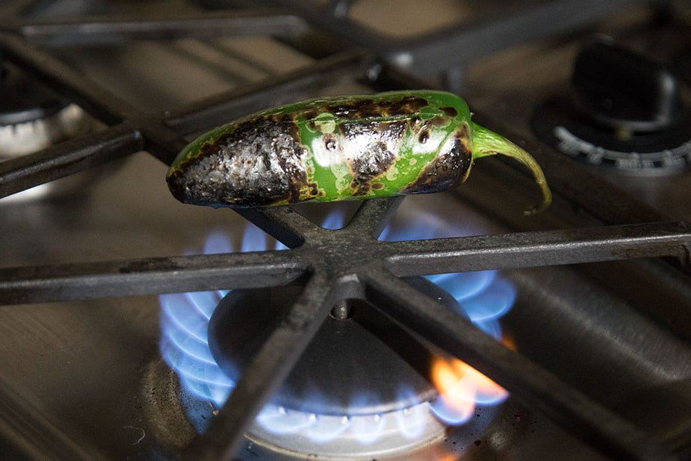 Roasting a jalapeno pepper over open flame.