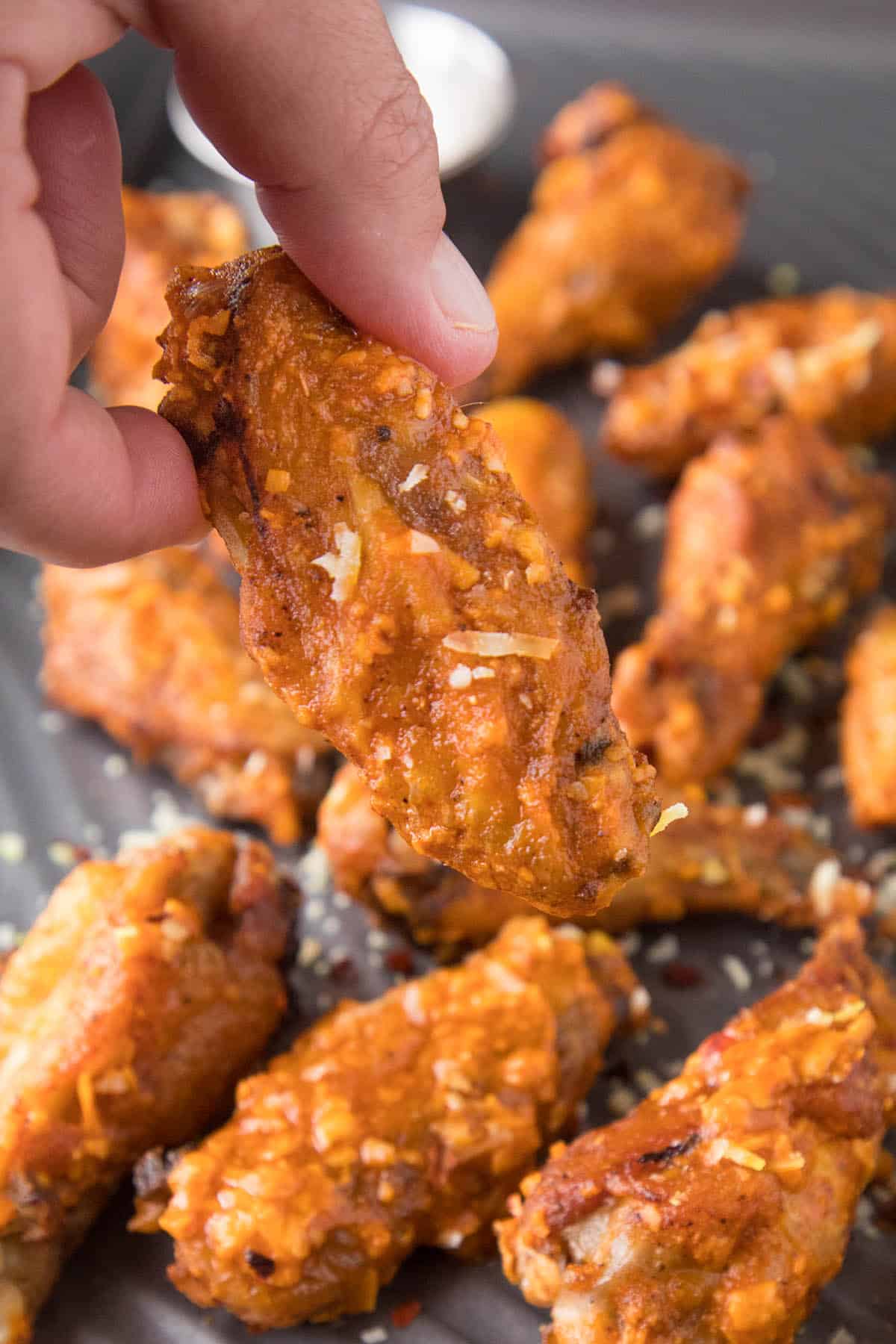 Holding a Garlic Parmesan Chicken Wing.