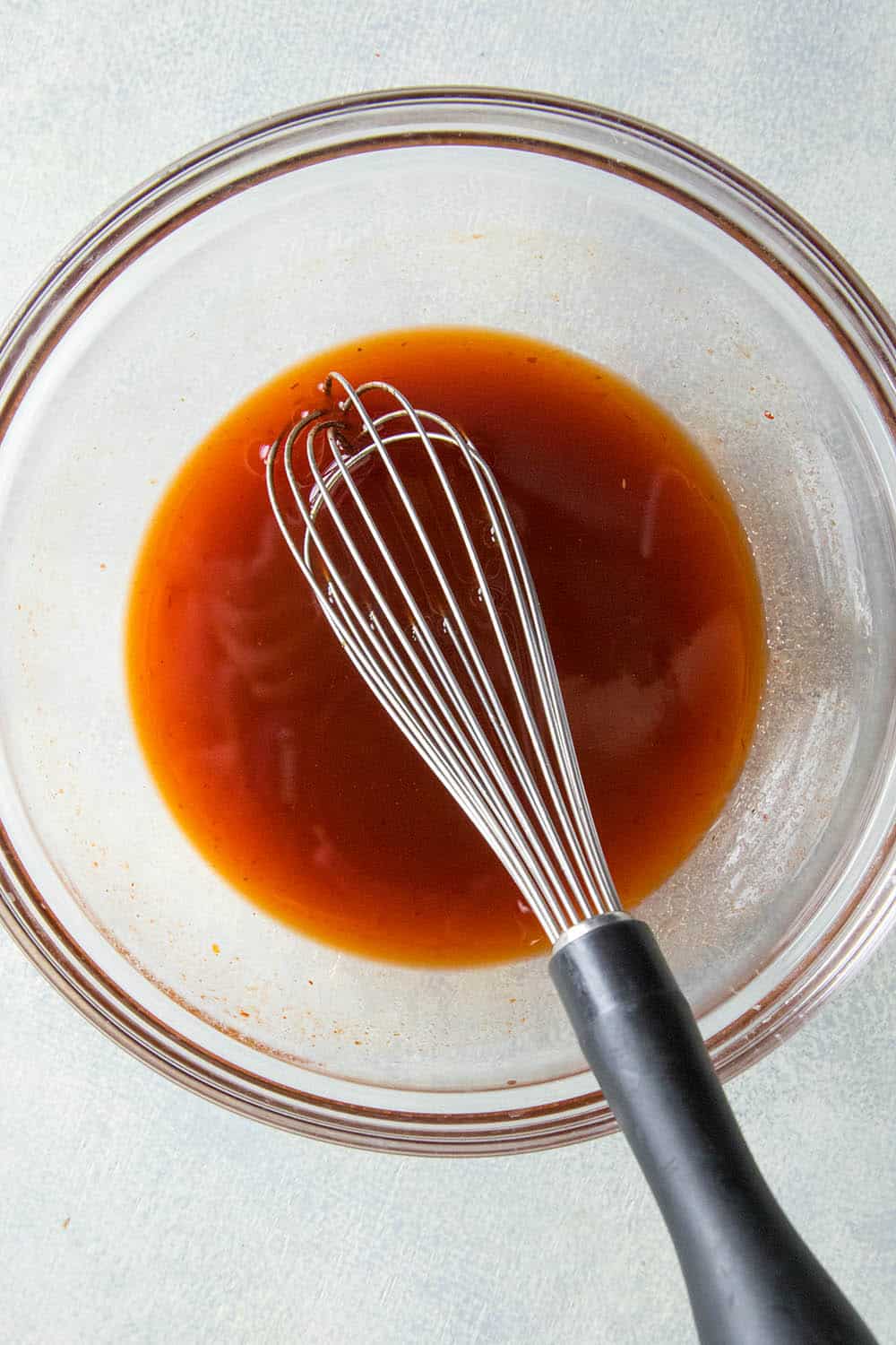 Whisking the honey-sriracha sauce.