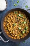 Lamb Vindaloo in a pan, garnished with sliced peppers, ready to serve